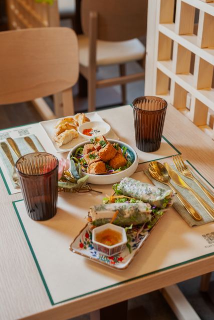 Tavolo con antipasti vietnamiti e bicchieri